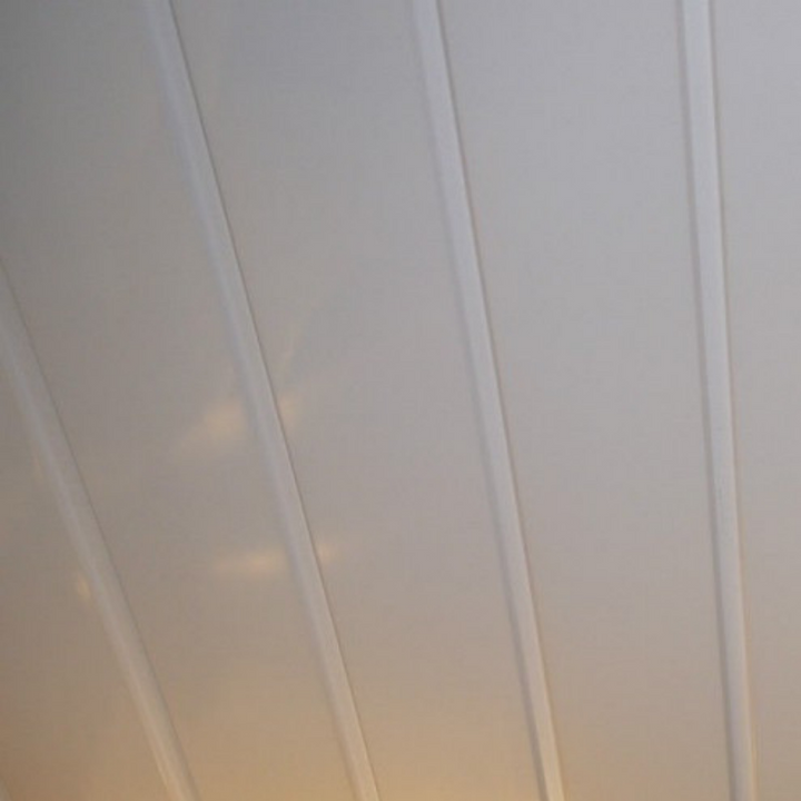 Abstract angled view of off-white vertical lines possibly representing curtains or architectural details with subtle warm light reflection in the background indicating sunrise or sunset.